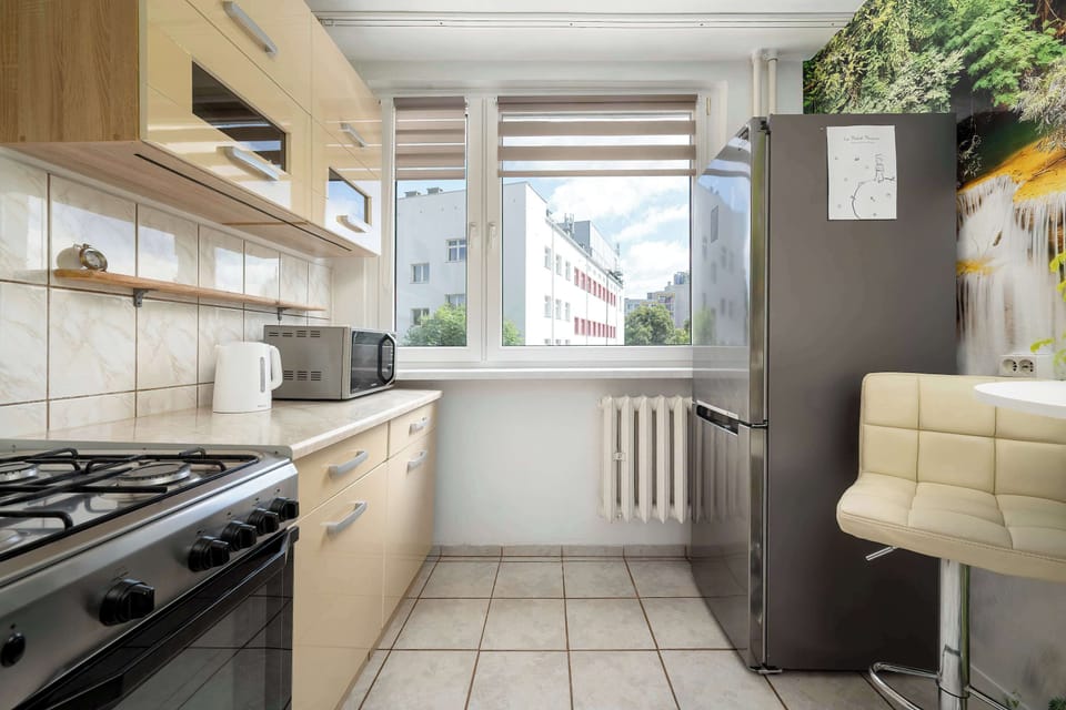Fully equipped separate kitchen with wooden cabinets, a gas stove, oven, refrigerator, and dining space.