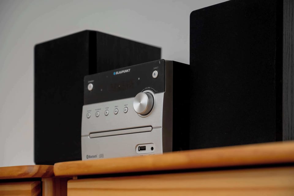 Close-up of the audio system placed on a wooden cabinet.