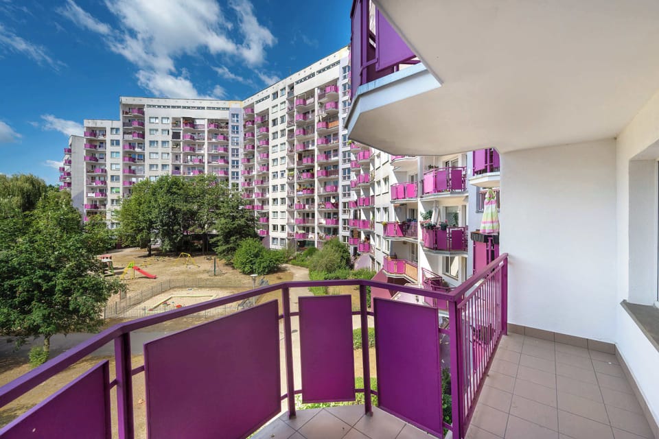 Spacious balcony overlooking the residential buildings and surrounding greenery.