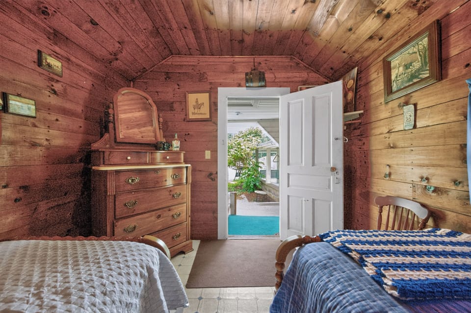 A wood-paneled bedroom featuring an antique wooden dresser.