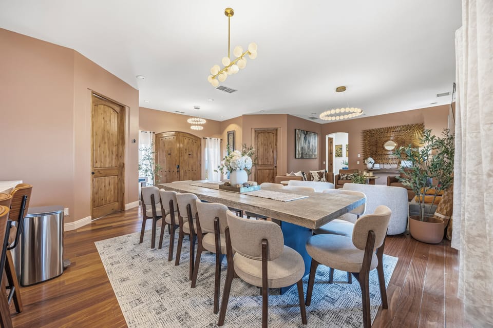 Open-concept dining for 10 with chic lighting and sunlit living area