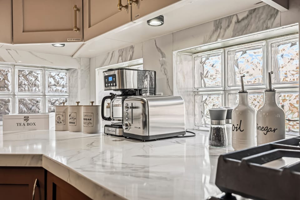 Sunny marble kitchen with coffee bar, toaster, and spice essentials