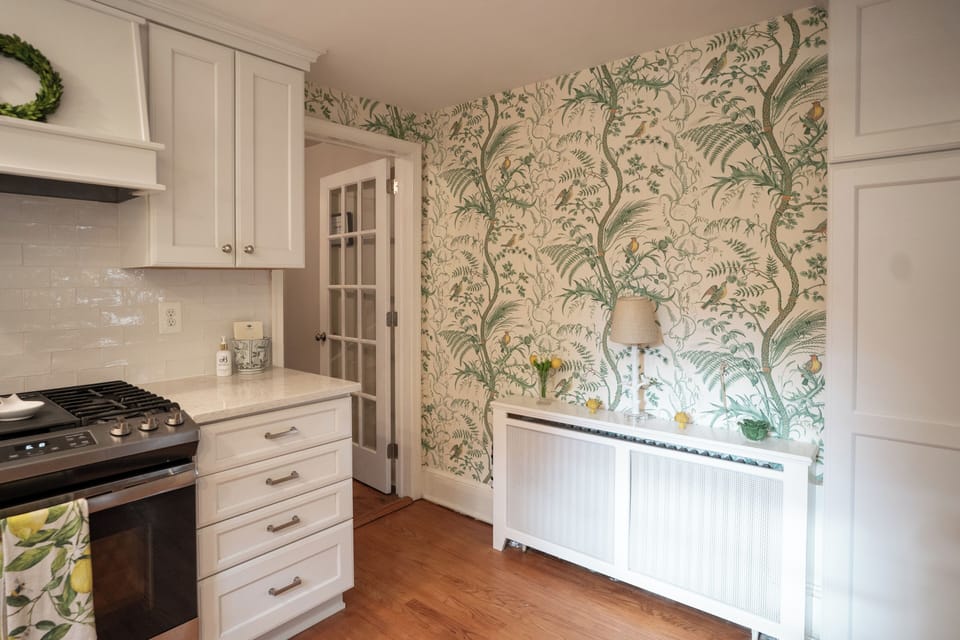Botanical wallpaper accent and pantry storage in the kitchen