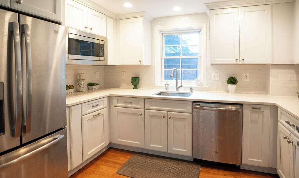 Fully renovated kitchen with quartz countertops, stainless appliances, and subway tile backsplash