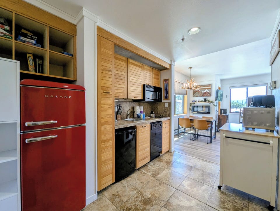 Step into your fully-equipped kitchen with vintage-style red refrigerator, modern appliances, and custom cabinetry—everything you need to whip up a meal or store your ski-day snacks.