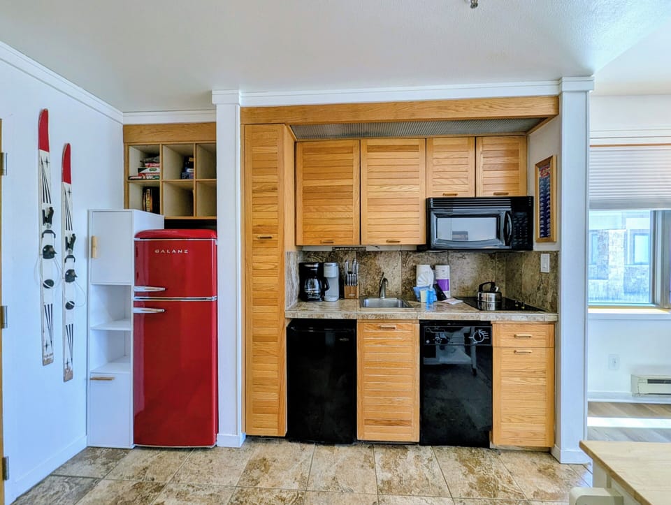 Your fully equipped kitchenette makes meal prep a breeze, with charming wood cabinetry, modern appliances, and granite countertops creating a warm, functional space for your culinary adventures.