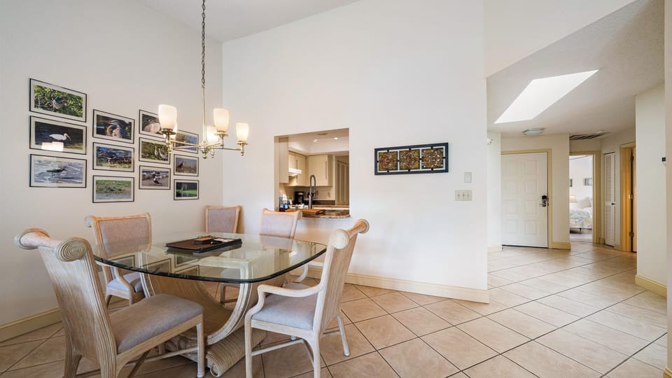 You'll love gathering around this elegant glass-top dining table, perfect for memorable meals. The open layout flows seamlessly into the kitchen and inviting living spaces beyond.