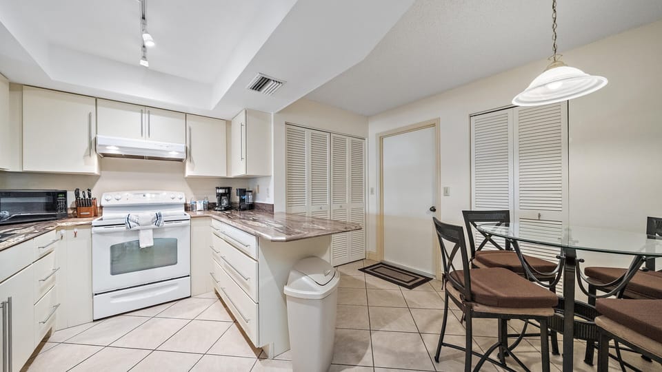 Your fully equipped kitchen invites you to prepare favorite meals with ease, while the adjacent dining area offers a warm, comfortable space to enjoy them together.