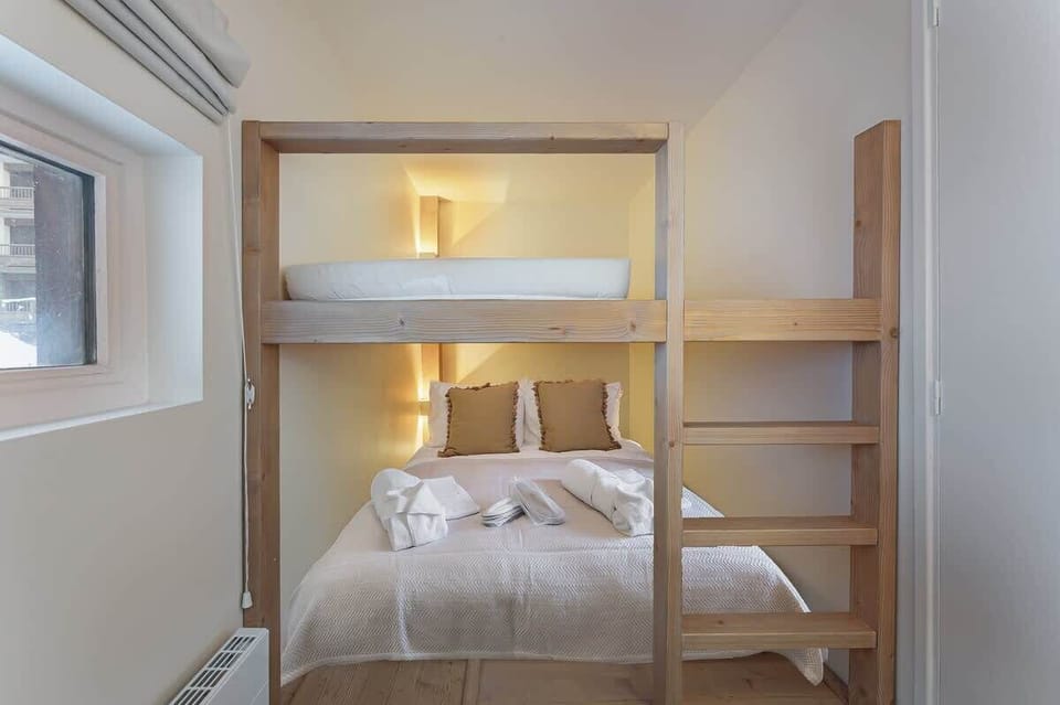Chambre lit superposés avec lit double en bas, fenêtre et rangement armoire