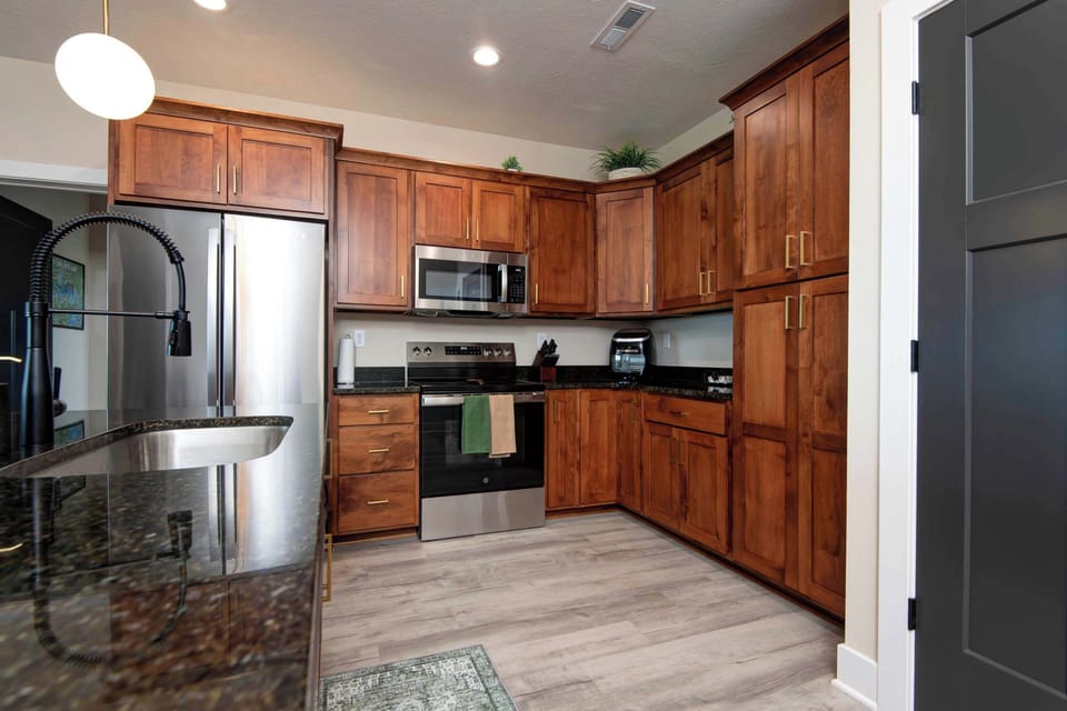 The fully equipped kitchen features stainless steel appliances, including a full-size refrigerator, stove, microwave, and dishwasher, along with everything you need to prepare meals during your stay.