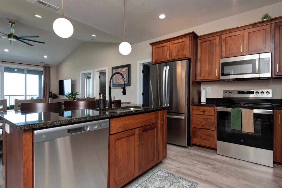 Bright and large kitchen featuring sleek stainless steel appliances, perfect for preparing family meals.