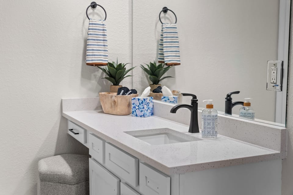 The primary ensuite has a spacious vanity and a separate tub, shower, and toilet area.