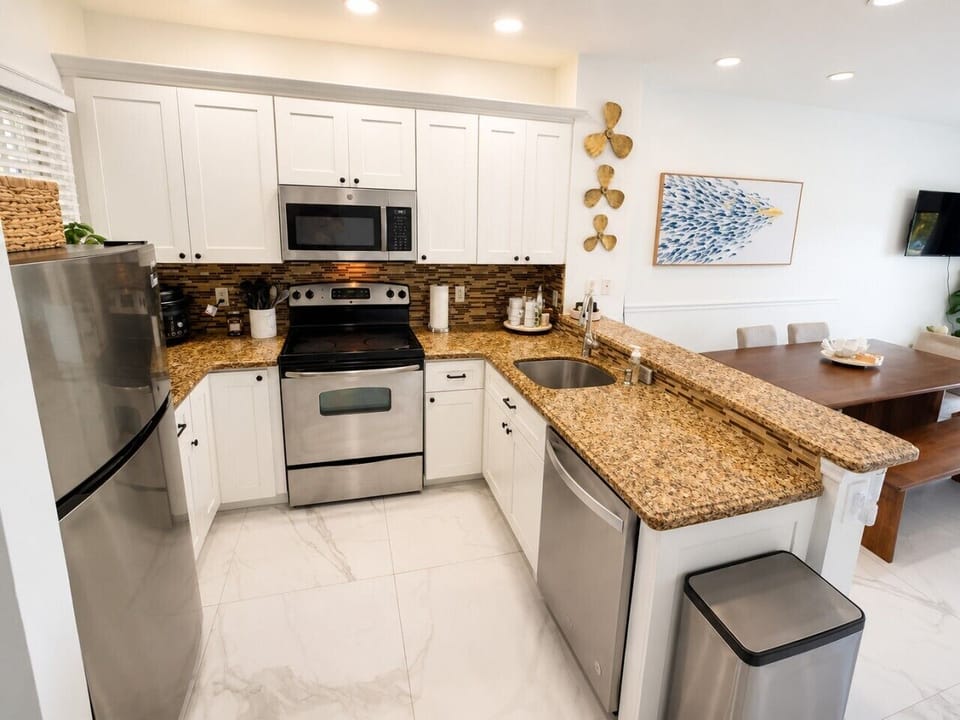 Fully equipped kitchen with stainless steel appliances, cookware, coffee maker, and everything needed for home-cooked meals.