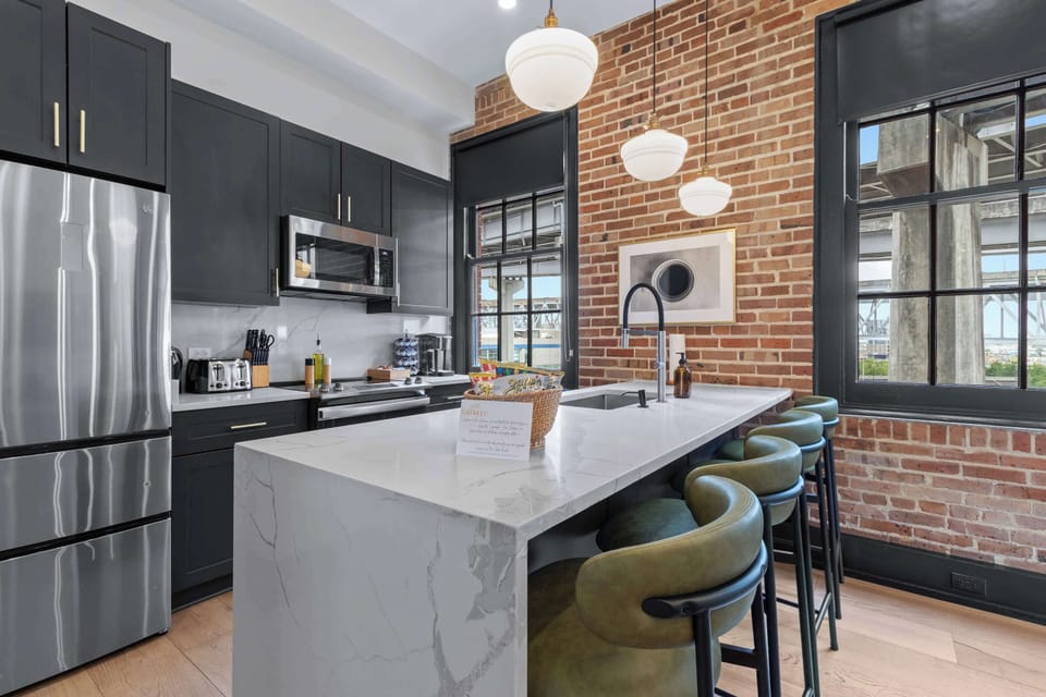 Cook or snack in style with a full kitchen featuring GE stainless appliances, cookware, and an island with bar seating. Ideal for short or extended stays, our kitchens make group travel in New Orleans easy and comfortable.