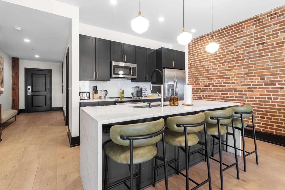 Cook or snack in style with a full kitchen featuring GE stainless appliances, cookware, and an island with bar seating. Ideal for short or extended stays, our kitchens make group travel in New Orleans easy and comfortable.
