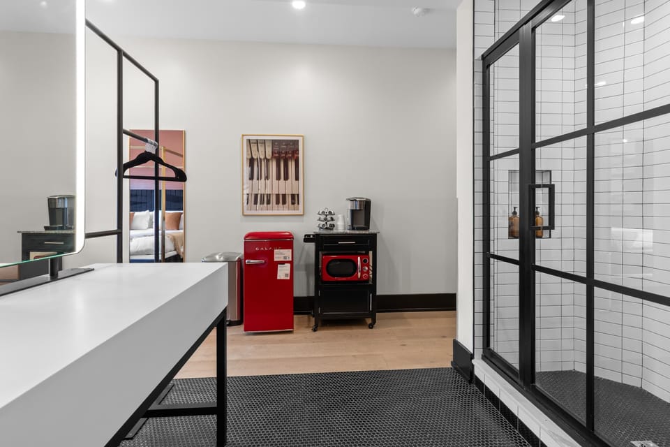 Refresh in the spacious bathroom featuring a large walk-in shower, double vanity with illuminated mirrors, plush towels, and premium finishes designed for comfort and convenience.