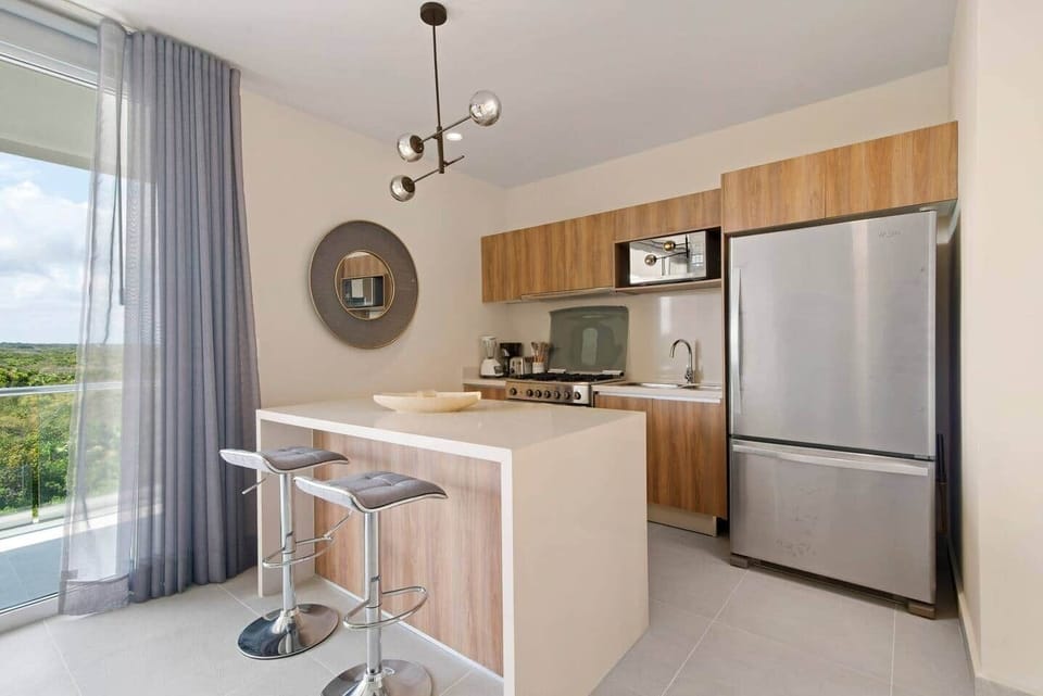 Fully equipped kitchen featuring two 5-gallon drinking water jugs, a dishwasher, microwave, coffee maker (with complimentary coffee), blender, toaster, full-size refrigerator, stove, and oven—everything you need to prepare and enjoy meals.