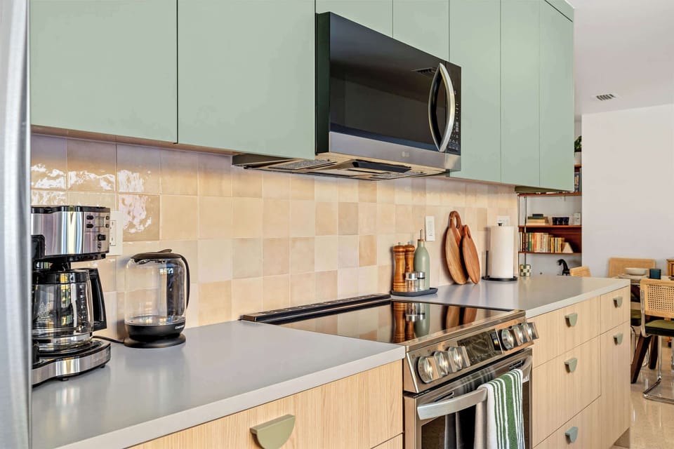 Full size range, microwave and tiled splashback in the kitchen.
