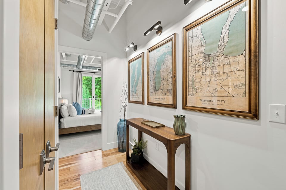 Stylish hallway with Traverse City map art and a cozy bedroom view.