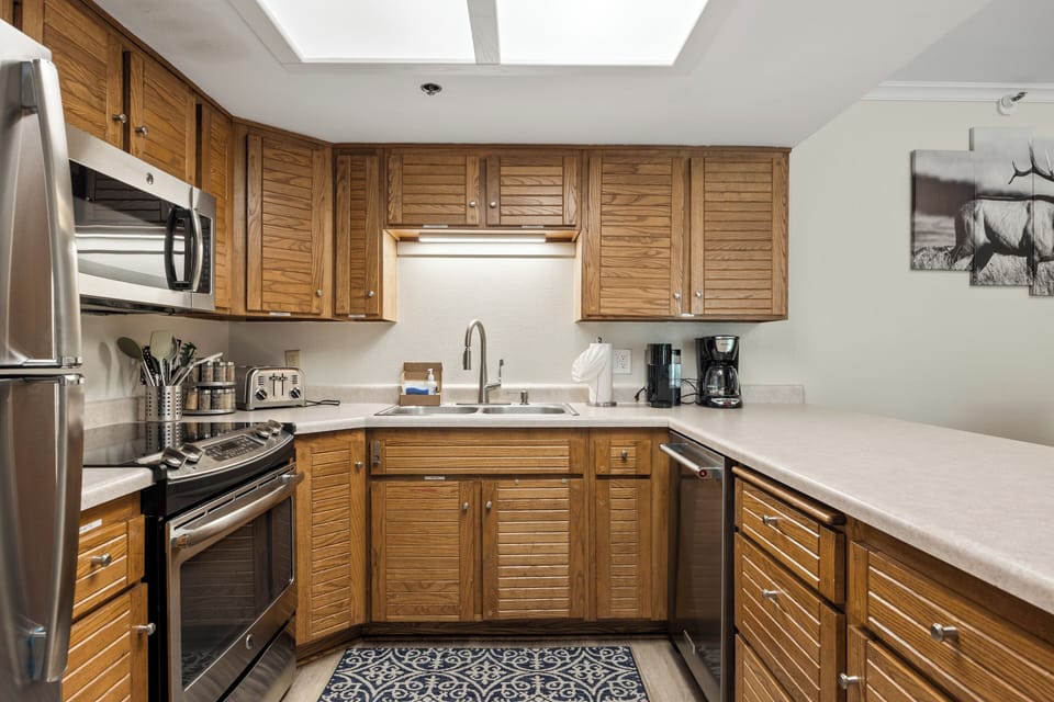 Prepare meals with ease in the well-stocked kitchen featuring full-size appliances, generous counter space, cookware, and a coffee maker for your morning brew.