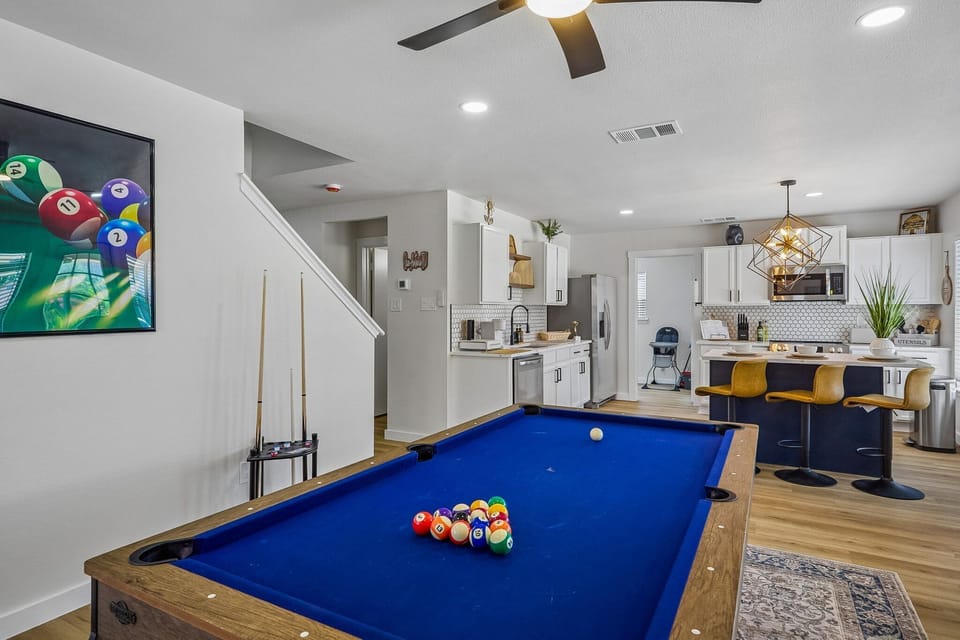 Game room meets gourmet kitchen with pool table and stylish island seating