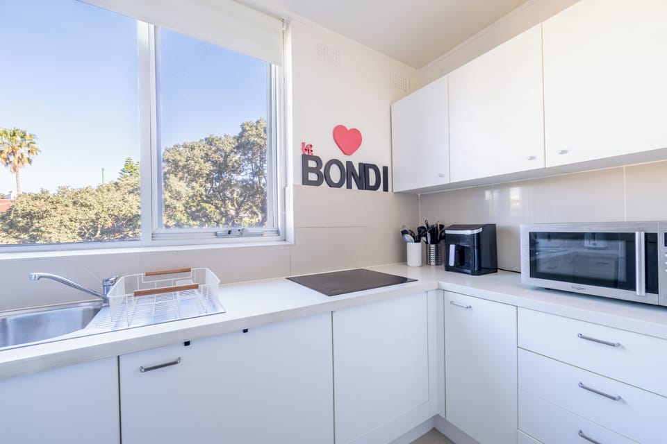 Kitchen with stovetop, microwave, and Bondi wall decor