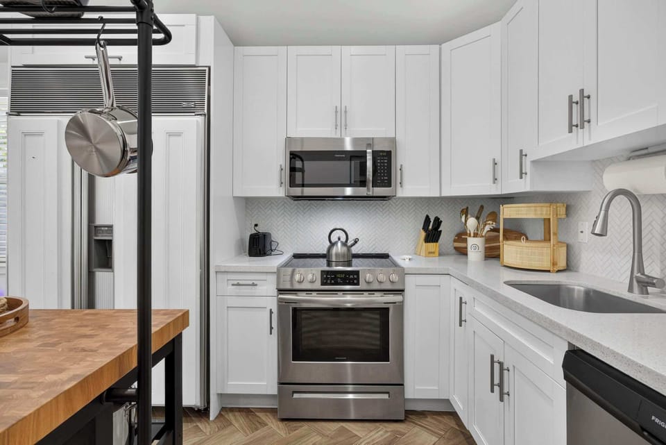 Full view of the fully stocked kitchen with microwave, oven range, and abundant cabinet storage for all your cooking needs