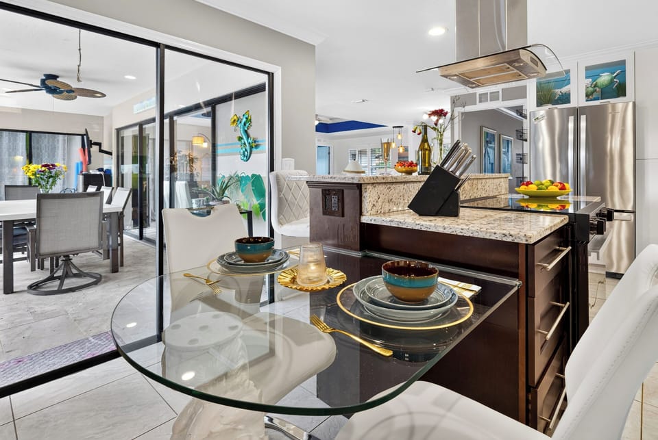 Dining nook and modern kitchen with island seating, sleek finishes, and easy flow to the patio.
