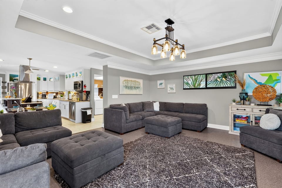 Comfortable family room with spacious seating, queen chest pull-out, a large TV, and tropical-inspired decor.