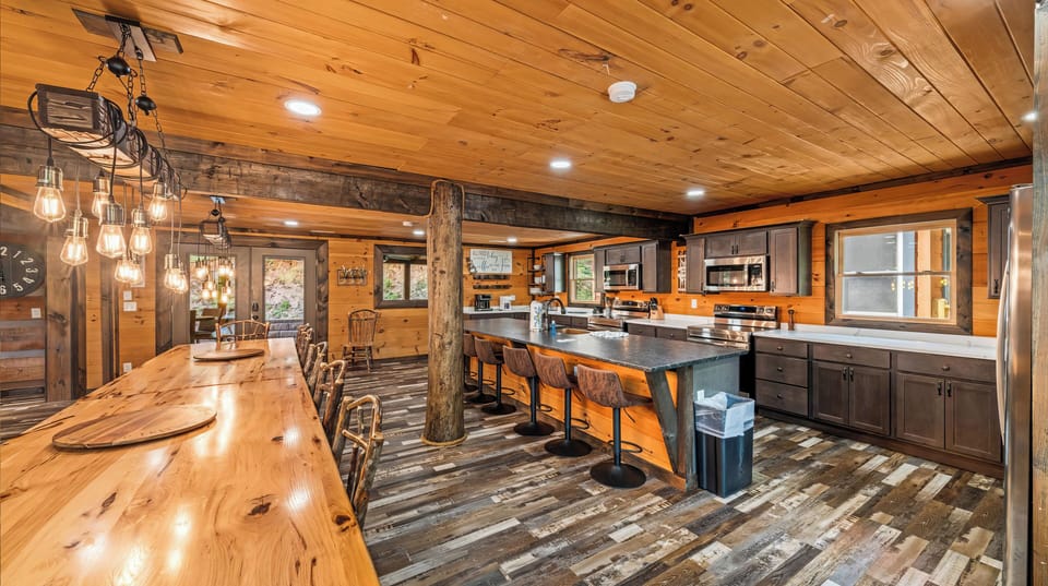 Fully equipped cabin kitchen with bar seating and an oversized dining table for shared meals.