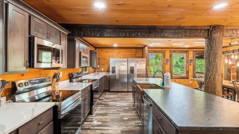 Fully equipped cabin kitchen with bar seating and an oversized dining table for shared meals.