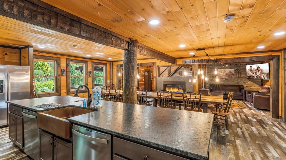 Fully equipped cabin kitchen with bar seating and an oversized dining table for shared meals.