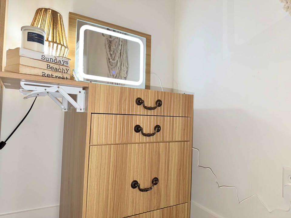 Vanity with a light and pull-out chair.