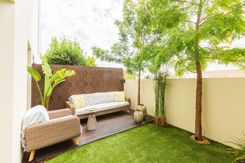 A secluded corner of the private garden, with an outdoor sofa, plants and natural shade. Ideal for reading, enjoying a late-afternoon conversation or simply relaxing after a day at the beach.