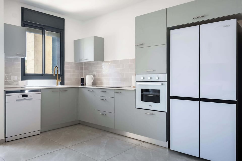 Sleek kitchen combining gray cabinetry, stainless steel appliances, and thoughtfully organized cooking workspace.
