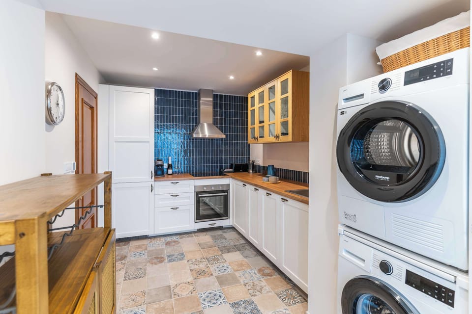 The separate kitchen features an induction hob, oven, dishwasher, fridge, coffee machine, kettle, washing machine and tumble dryer. Cookware, tableware and basic utensils are provided, along with coffee, tea and spices.