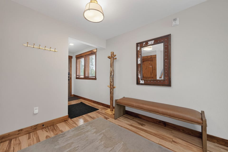 Step into your welcoming entryway with warm wood floors, a rustic coat rack for your jackets, and a cozy bench where you can slip off your shoes after a day of adventure.