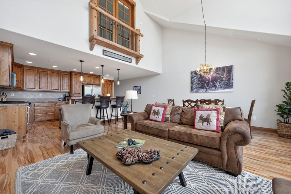 Relax in this soaring open-concept living space where rustic wood tones meet modern comfort. Unwind on leather sofas, gather in the full kitchen, and enjoy the warm mountain lodge ambiance throughout.