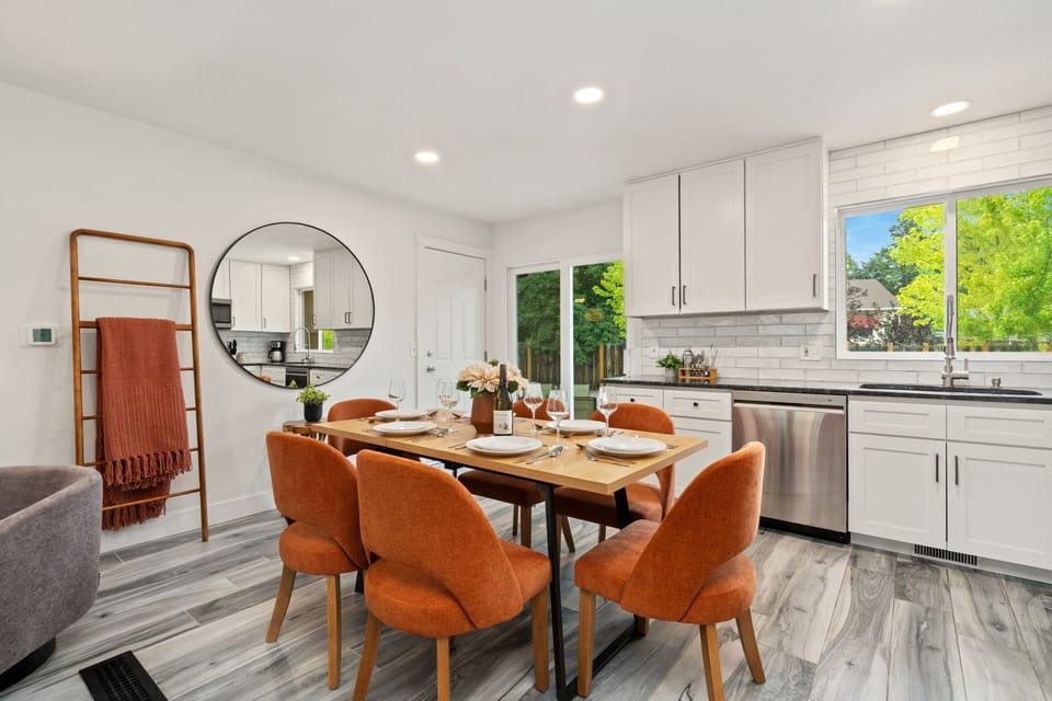 Beautifully styled dining space with sunlight streaming through large windows.