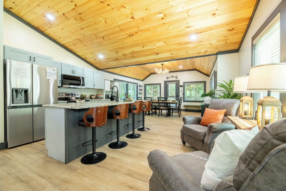 Picture yourself in this open-concept retreat, where a stunning ceiling soars above your fully-equipped kitchen, cozy seating, and dining area—perfect for gathering, cooking, and unwinding together.