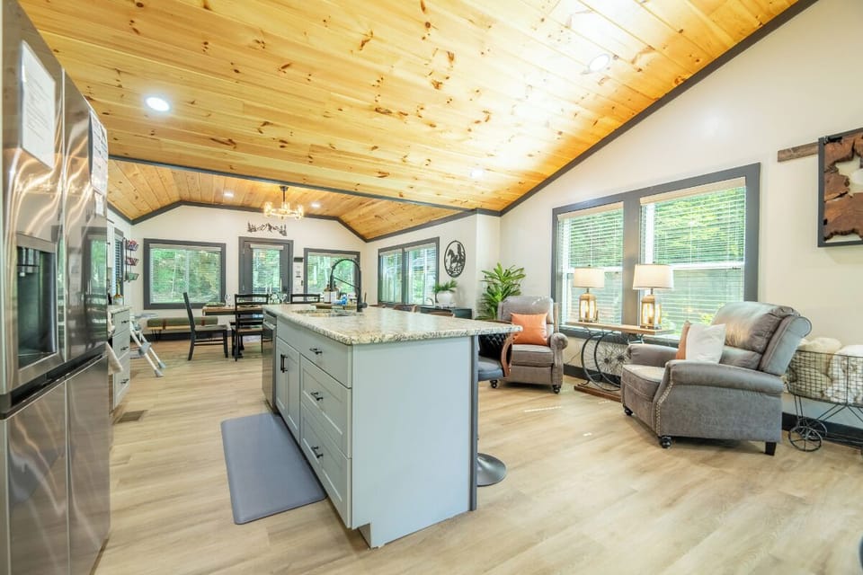 Unwind in your open-concept retreat, where warm wood ceilings and abundant natural light create a welcoming atmosphere for cooking, relaxing, and making memories together.