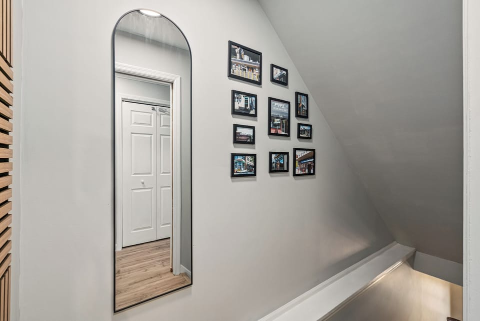 Bright stair landing with arched mirror and stylish gallery wall