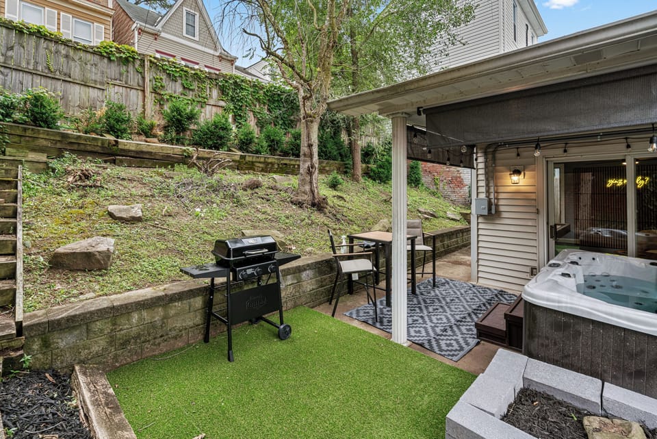 Private patio with hot tub, grill, and cozy covered outdoor seating