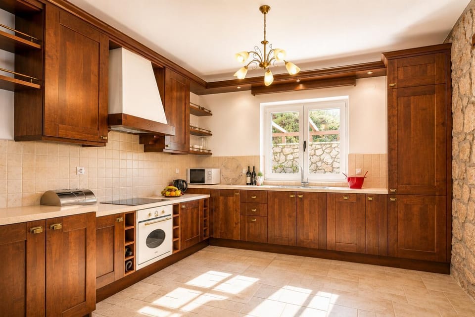 Fully equipped kitchen with warm wooden cabinetry and stone tile flooring.