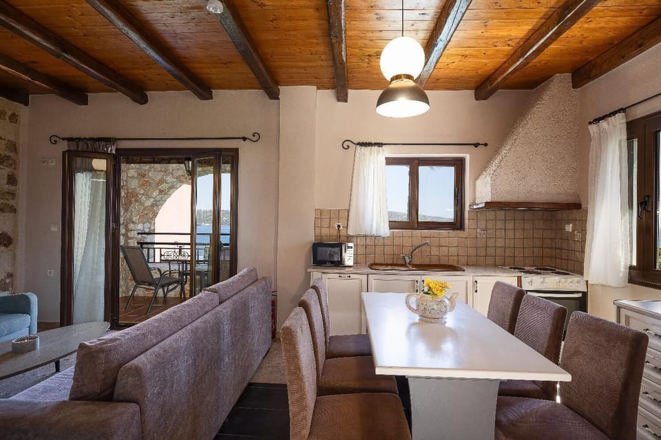 A wide view of the villa's upper-level open-concept interior, showcasing the connection between the living space, dining area, and compact kitchen.