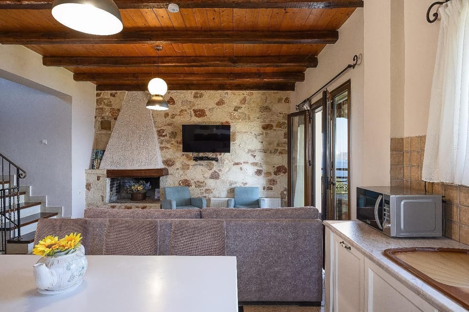 An alternate, wide view of the open-concept living area, captured from behind the kitchen counter to show the layout from the dining area to the stone accent wall.