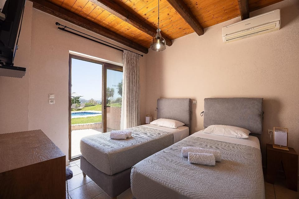 An interior view of a twin bedroom within the villa, maintaining the property's clean, modern aesthetic paired with rustic accents.