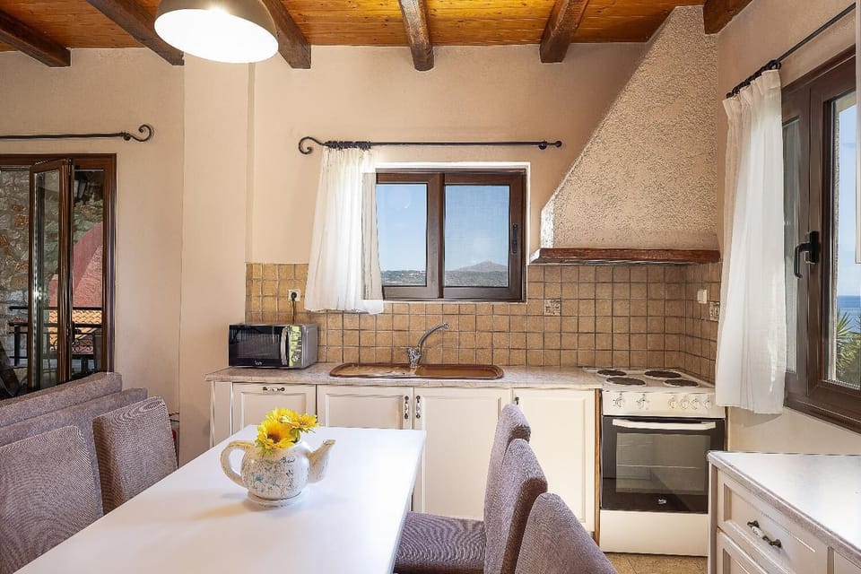 A close-up view focusing entirely on the kitchen and dining area within the villa's open-concept space.