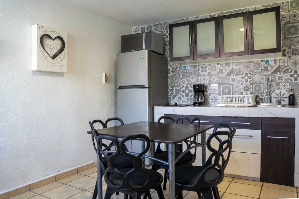 Handy kitchenette and dining table with cheerful tilework, ready for easy home-cooked meals