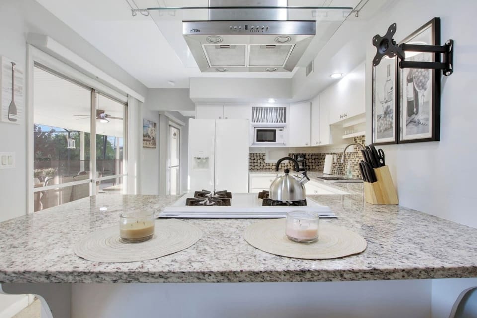 Open kitchen with access to rear patio and serving bar with stools
